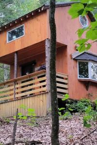 a house with a fence in front of it at Vana Kuti-cabin in the woods in Camden