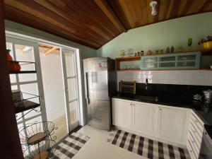 a kitchen with a refrigerator and a tile floor at Casa de praia tranquilidade e conforto in Búzios