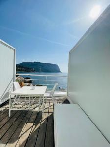 einen Balkon mit einem Tisch, Stühlen und Meerblick in der Unterkunft Hotel de La Plage - Mahogany in Cassis