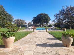 a stone walkway with three potted plants on it at Villa Castiglione 1863 - The real Sicilian holiday in Ragusa