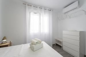 biała sypialnia z łóżkiem i komodą w obiekcie Apartamentos Joya del Mar w mieście Torre del Mar +9 zdjęć