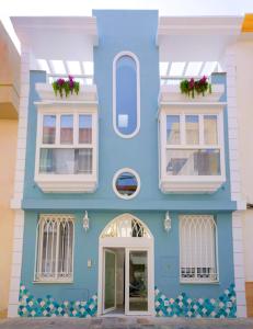 niebiesko-biały budynek z białymi oknami w obiekcie Apartamentos Joya del Mar w mieście Torre del Mar