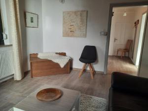 a living room with a table and a chair at Ferienhaus Natur und Stil in Rieneck