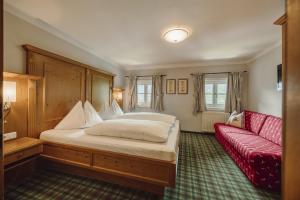 a bedroom with a bed and a red couch at Chalet Lerch in Sankt Johann im Pongau