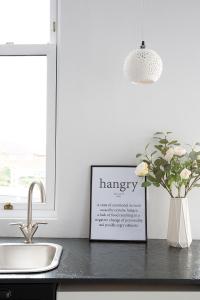un bancone della cucina con un cartello della farmacia e un vaso di fiori di Beautiful first floor apartment a Poulton-le-Fylde