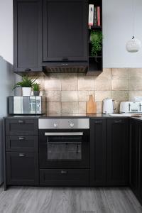 a kitchen with black cabinets and a black oven at Beautiful first floor apartment in Poulton le Fylde