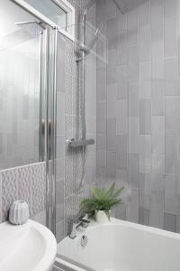 y baño con ducha, lavabo y bañera. en Beautiful first floor apartment, en Poulton le Fylde