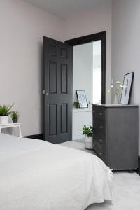 een slaapkamer met een bed, een dressoir en een spiegel bij Beautiful first floor apartment in Poulton le Fylde
