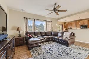 een woonkamer met een leren bank en een plafondventilator bij 21361 White Ash Ct in Parker