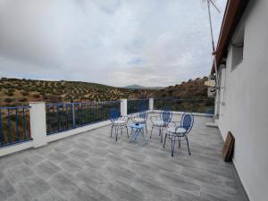 eine Terrasse mit Stühlen und Tischen auf dem Balkon in der Unterkunft Vivienda rural del salado in Jaén