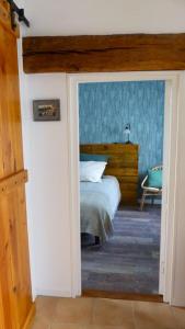 um quarto com uma cama com uma parede azul em Maison d'une chambre avec jardin a Concremiers em Concremiers