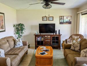 a living room with couches and a flat screen tv at Sea Club Condo #6 in Clearwater Beach