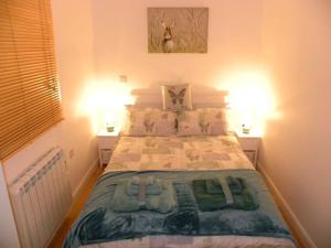 a bedroom with a large bed with two lamps at Oakey Orchard - cosy apartment in Tamar Valley, Cornwall in Saint Dominick