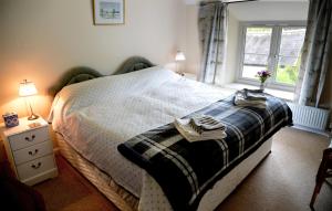 1 dormitorio con cama y ventana en Deepaller Farm, en Tiverton