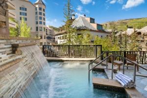 a water fall in a city with a building at St James Place by East West Hospitality in Beaver Creek