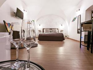 2 copas de vino en una mesa en una habitación con cama en RAVI romantic jacuzzi suite, en Bari