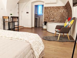 1 dormitorio con cama, silla y bañera en RAVI romantic jacuzzi suite, en Bari