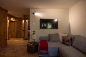a living room with a couch and a tv on the wall at Casa Betulla in Cortina dʼAmpezzo