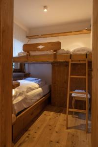 a bunk bed room with two bunk beds and a ladder at Casa Betulla in Cortina dʼAmpezzo