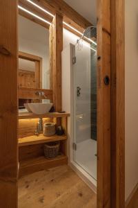 a bathroom with a sink and a glass shower at Casa Betulla in Cortina dʼAmpezzo