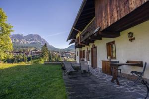 un patio de una casa con mesa y sillas en Casa Betulla, en Cortina dʼAmpezzo