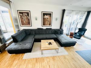a living room with a black couch and a coffee table at Exclusive High-quality Apartment Spessart in Marktheidenfeld
