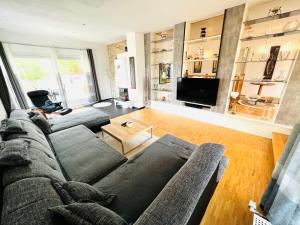 a living room with a couch and a tv at Exclusive High-quality Apartment Spessart in Marktheidenfeld