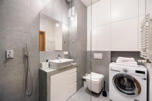 bagno con lavatrice e lavandino di Jaktorowska Comfy Apartment a Varsavia