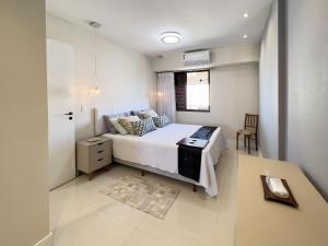 Un dormitorio con una cama y una mesa. en Lindo Flat com Varanda e Vista Panorâmica no Coração da Barra Pertinho de Tudo B1-0029, en Río de Janeiro