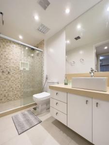 a bathroom with a sink and a toilet and a shower at Lindo Flat com Varanda e Vista Panorâmica no Coração da Barra Pertinho de Tudo B1-0029 in Rio de Janeiro