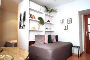 a room with a couch and a table and shelves at Estudio Lavapiés cerca de Antón Martín in Madrid