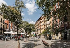 a city street with a bench and tables and buildings at Estudio Lavapiés cerca de Antón Martín in Madrid