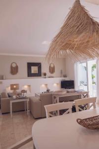 a living room with a couch and a table at Villa Tiguaro Piscina Climat Jacuzzy AC Villa 9 12 in Corralejo