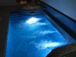 a swimming pool with a blue light in the water at Hotel Argentina in Atlántida