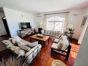 ein Wohnzimmer mit Sofas und einem TV in der Unterkunft La Mansa Riverside in Esquina