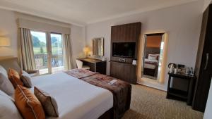 a hotel room with a large bed and a television at Coppid Beech in Bracknell