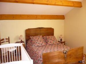 a bedroom with a bed with a wooden headboard at Gite de la croix in Apinac
