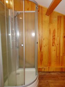 a shower with a glass door in a bathroom at Gite de la croix in Apinac