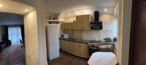 uma cozinha com armários de madeira e um frigorífico branco em ARB Kaunas em Kaunas