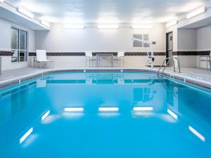 a swimming pool with blue water in a building at Country Inn & Suites by Radisson, Toledo, OH in Maumee
