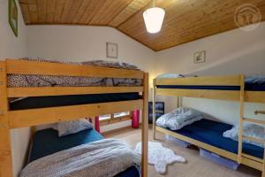 a bedroom with three bunk beds in a house at Les blancs moutons in Gumières