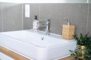 FULL HOUSE Premium Apartments - Zwickau rooftop في تسفيكاو: مغسلة الحمام فيها موزع صابون