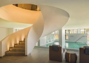 a lobby with a staircase and a swimming pool at Longevity Health & Wellness Hotel - Adults Only in Alvor