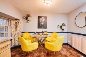 a dining room with yellow chairs and a table at Perfect Place To Stay Fast Free WiFi in Edinburgh