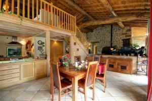 een grote keuken met een houten tafel en stoelen bij Le clos du martouret in Roisey