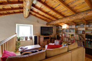 een woonkamer met een bank en boekenplanken bij Le clos du martouret in Roisey
