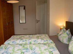 a bedroom with a bed and a mirror on the wall at Ferienwohnung Gute Zeit - Apartment 1 in Bleialf