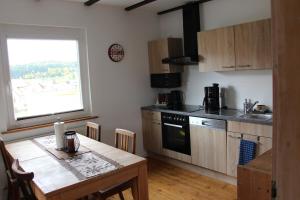 a kitchen with a wooden table and a kitchen with a window at Apartment Angelina in Bitz