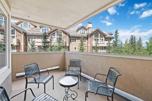 a balcony with chairs and tables and a building at St James Place by East West Hospitality in Beaver Creek