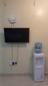 a room with a tv on the corner of a wall at Woodgreek Studio Apartment 4B27 in Kisii